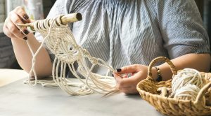 Female hands weave macrame home workshop. Boho lifestyle