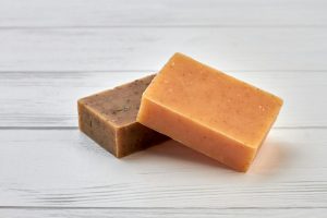 Two homemade brown spa soap on wooden table.