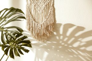 wall hand made macrame with monstera plant in the room