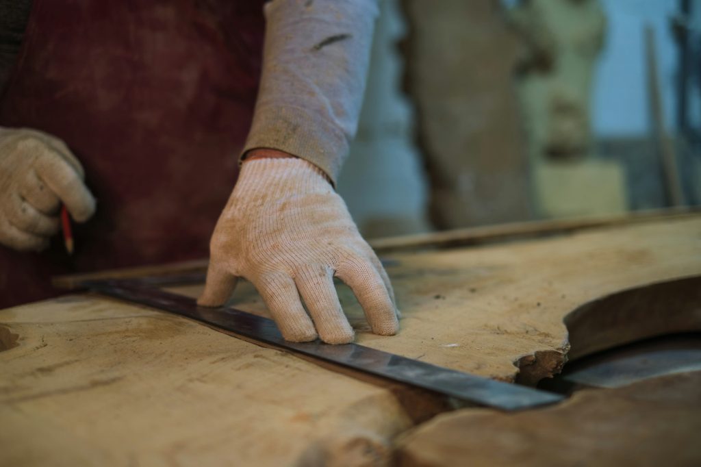 A woodworker's precise measurement, detail emphasized. Resonates with the DIY movement's push for