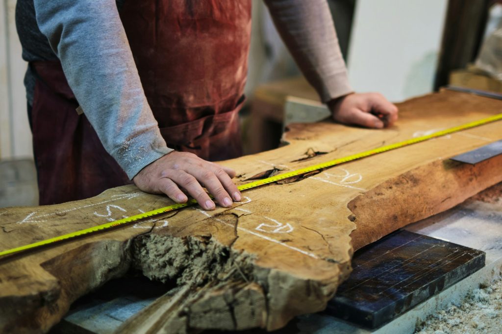 A woodworker's precise measurement, detail emphasized. Resonates with the DIY movement's push for