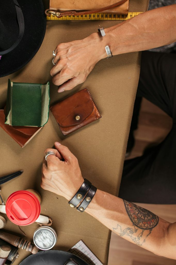Leather goods master and handmade leather wallets. Workflow in the workshop.